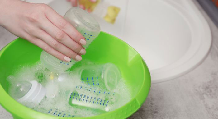 شستن شیشه شیر نوزاد با آب گرم و مایع